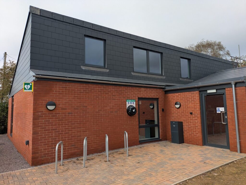 A brick ground floor and entrance, with grey slate roof